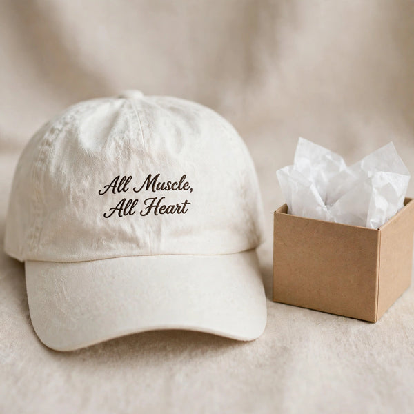 White washed dad hat with All Muscle All Heart embroidery, gift presentation